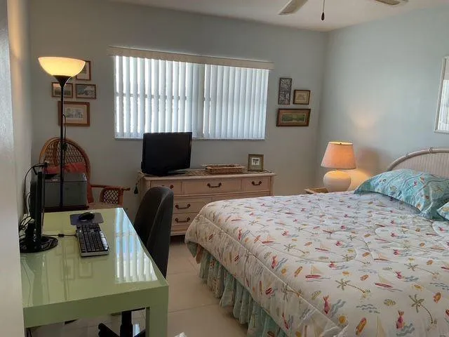 a bedroom with a bed and a lamp on dresser