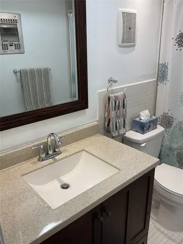 a bathroom with a sink a toilet and a mirror