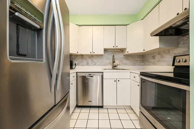 a kitchen with a sink stove and cabinets