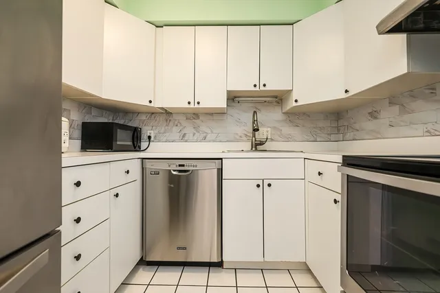 a kitchen with granite countertop white cabinets and white appliances
