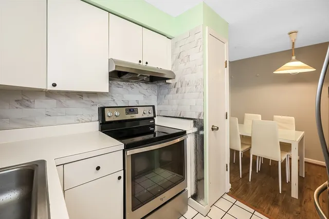 a kitchen with granite countertop a stove a microwave a dining table and chairs