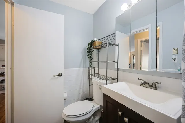 a bathroom with a sink vanity mirror and toilet