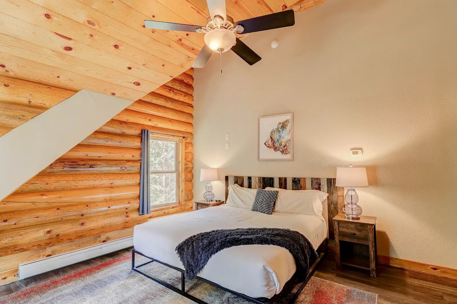 395 Miners Way Fairplay, CO 80440 - Photo 15 of 43 a bed sitting in a bedroom next to a window with a chandelier