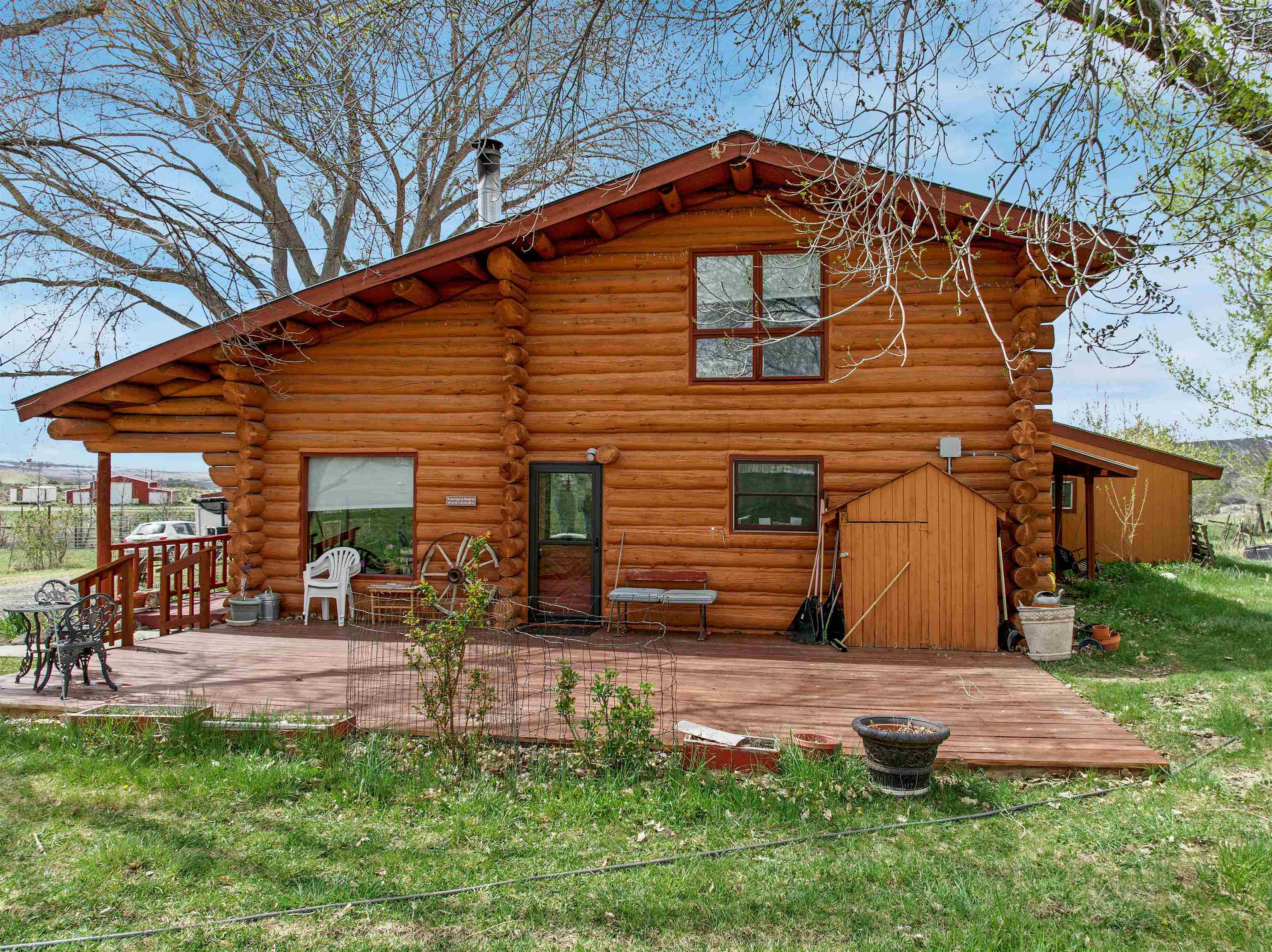 9709 3605 Road Hotchkiss, CO 81419 - Photo 2 of 42 a backyard of a house with yard and outdoor seating