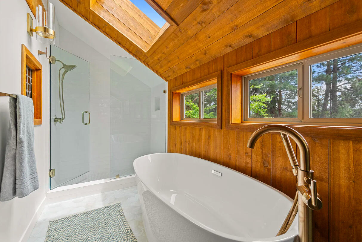 60359 Arnold Market Road Bend, OR 97702 - Photo 43 of 64 primary bath: soaking tub with nature views and tiled walk-in shower, skylights