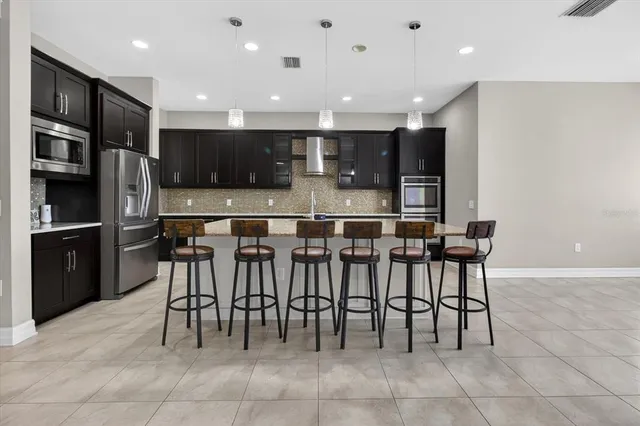 a large kitchen with a large counter top a sink a window and stainless steel appliances