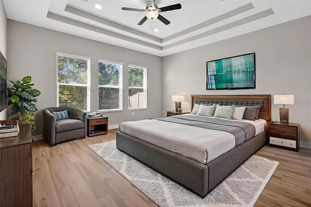 a view of an empty room with wooden floor and a ceiling fan