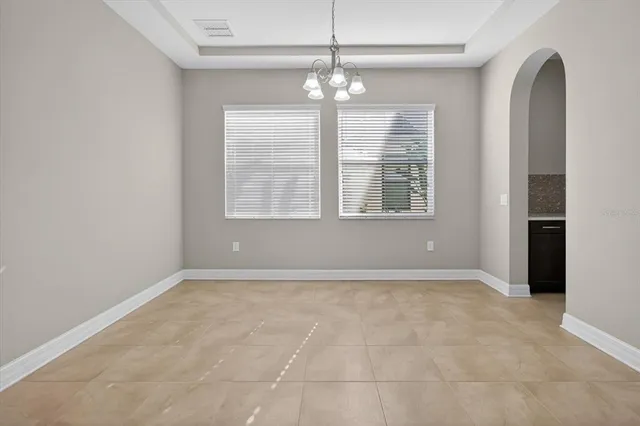 a kitchen with stainless steel appliances granite countertop a table and chairs in it