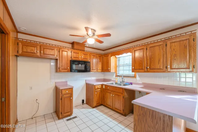 a kitchen with a sink window and cabinets