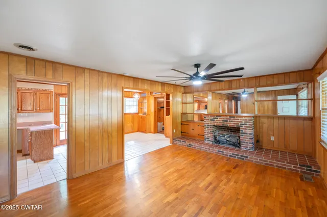 a view of empty room with a fireplace and wooden floor