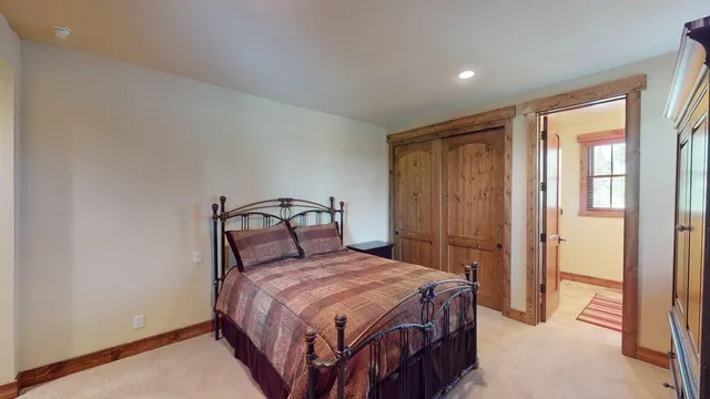 a bedroom with a bed a closet and a large window