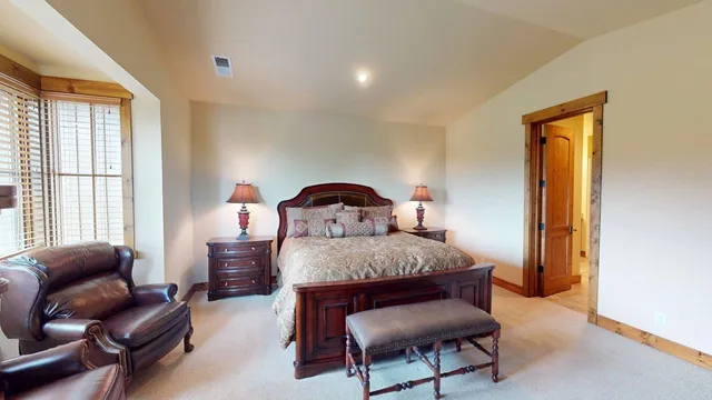 a bedroom with a bed chair and window