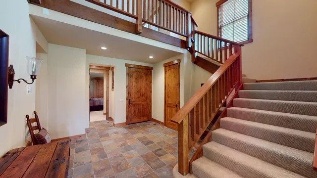 a view of staircase with lots of frames on wall and a window