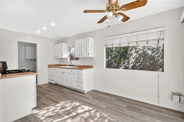 a kitchen with white cabinets and window