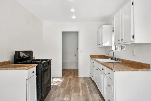 a kitchen with granite countertop a sink stove and cabinets