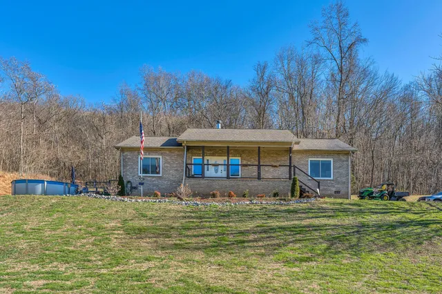 a front view of house with yard and trees in the background