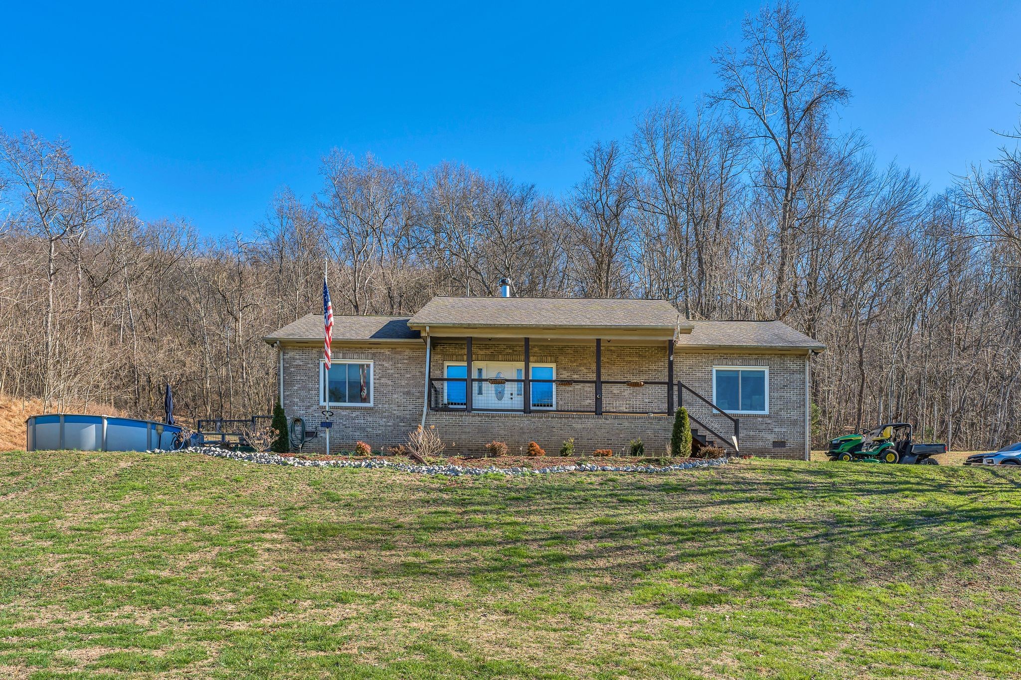 a front view of house with yard and trees in the background