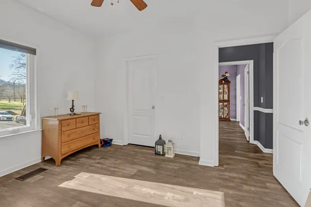 a view of a hallway with entryway wooden floor and cabinet
