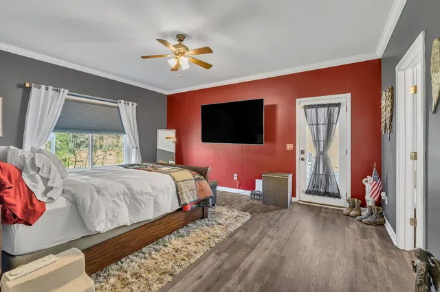 a bedroom with a bed and a flat tv screen on dresser