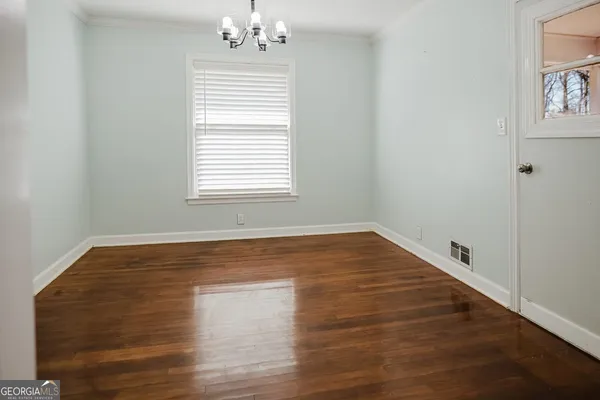a view of empty room with wooden floor