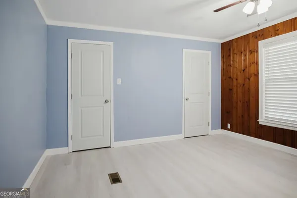 an empty room with windows and closet
