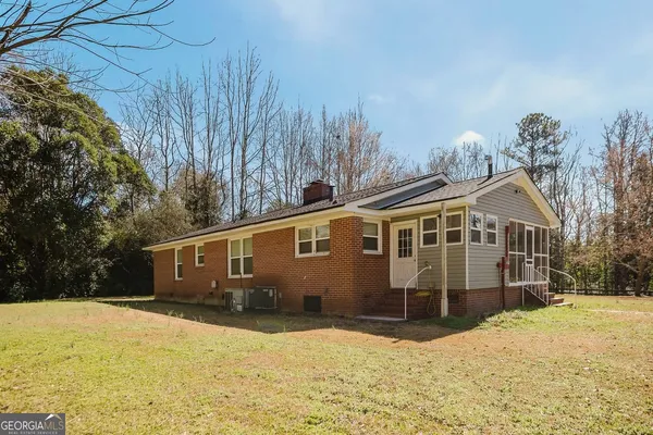 a front view of a house with a yard covered with snow