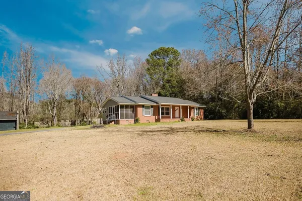 a front view of a house with a yard covered in snow