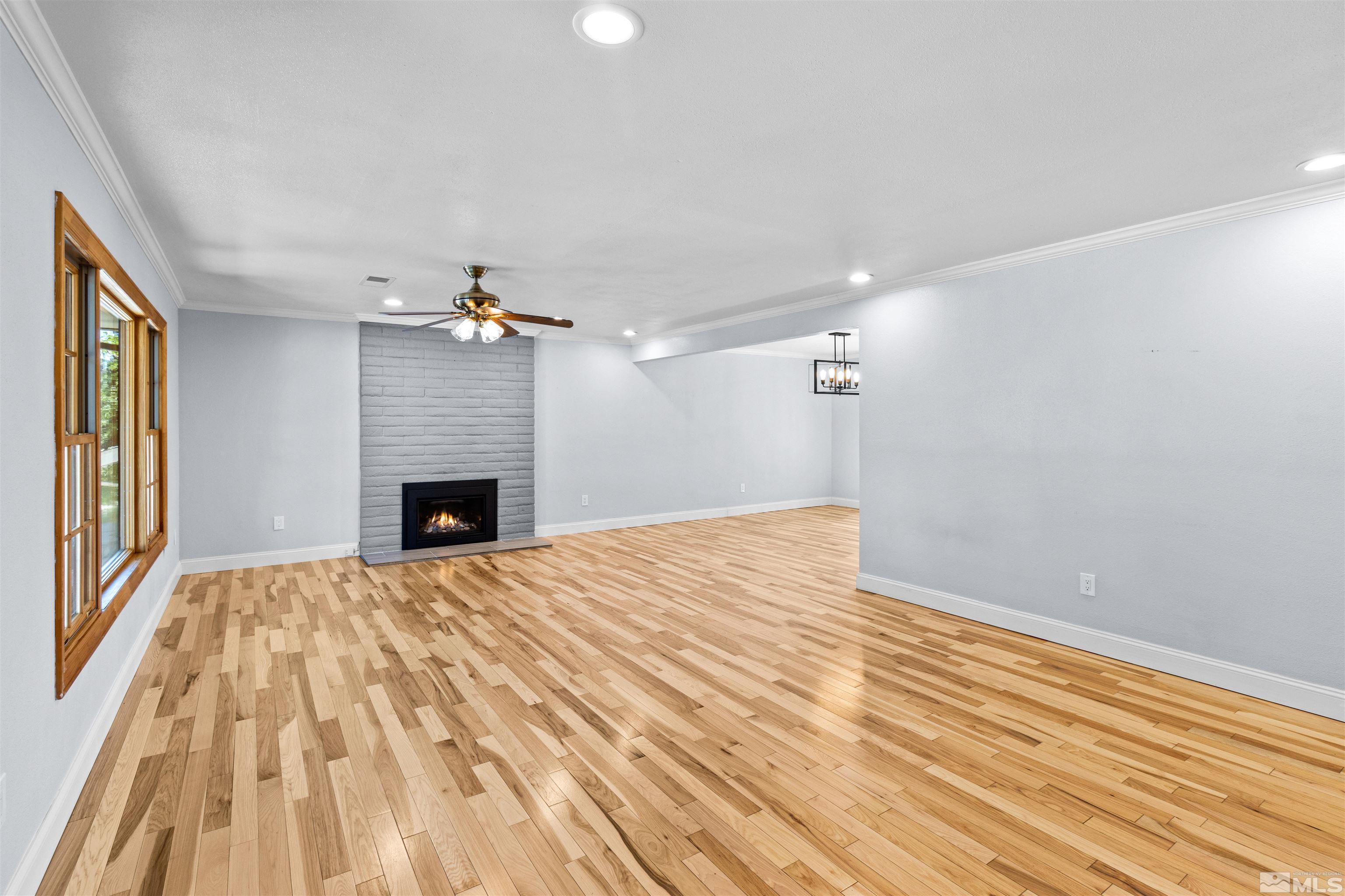 14285 Virginia Foothills Drive Reno, NV 89521 - Photo 21 of 39 a view of empty room with wooden floor and fireplace