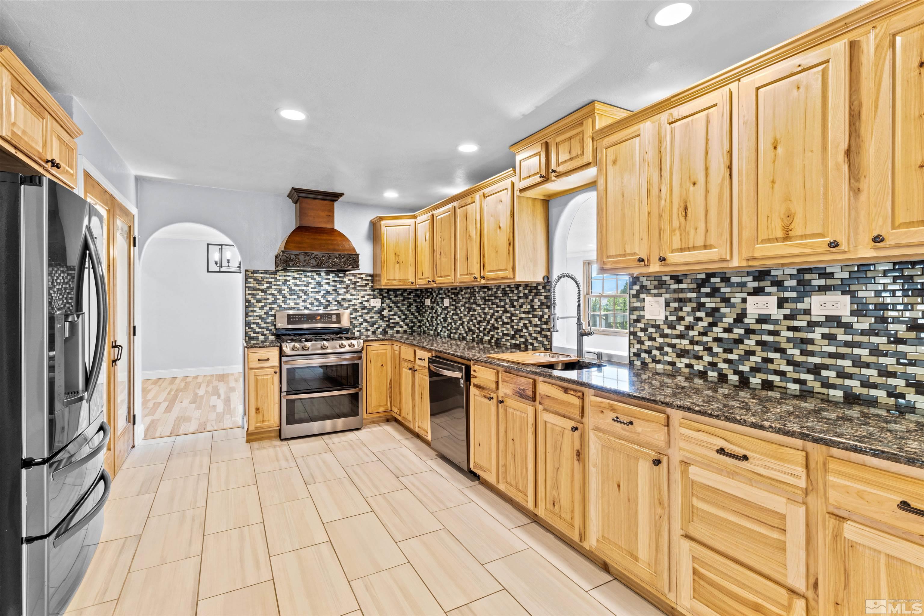 14285 Virginia Foothills Drive Reno, NV 89521 - Photo 3 of 39 a kitchen with granite countertop a stove a sink and a refrigerator