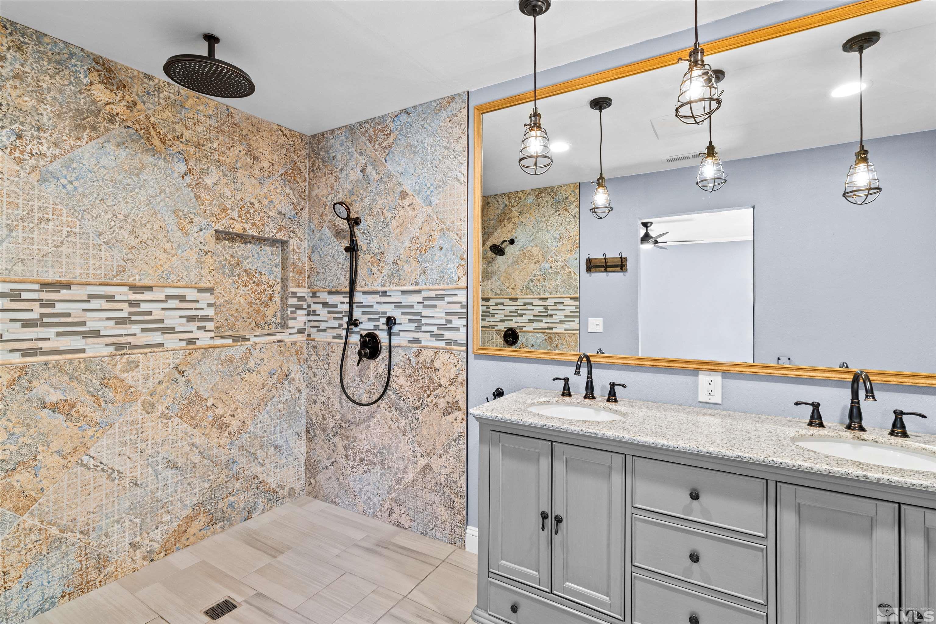 14285 Virginia Foothills Drive Reno, NV 89521 - Photo 9 of 39 a bathroom with a granite countertop sink a mirror and shower