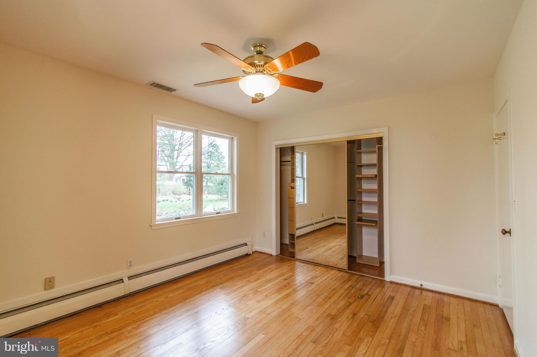 13407 Roxbury Road Silver Spring, MD 20904 - Photo 13 of 23 an empty room with wooden floor fan and windows