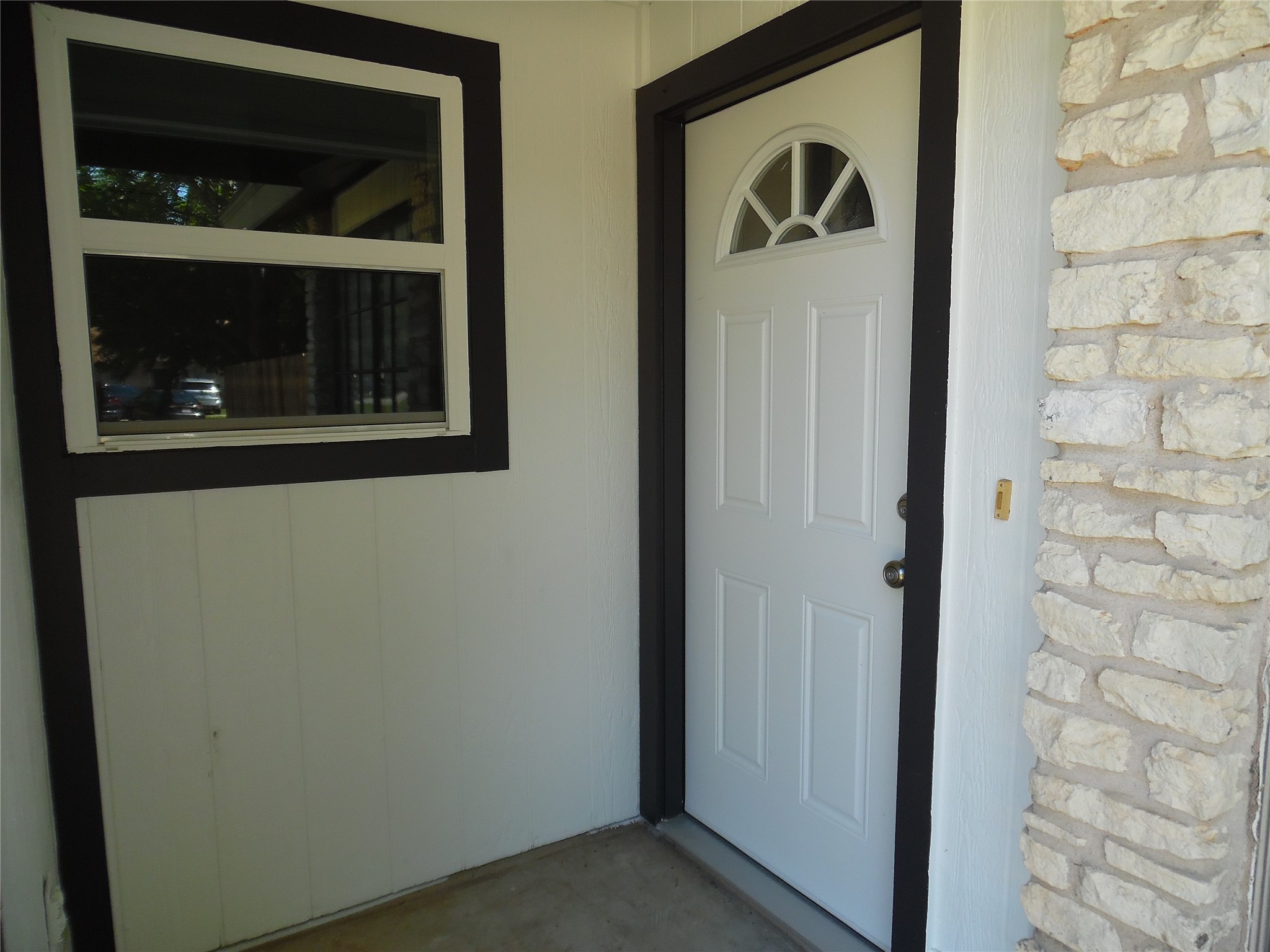 7400 Dixie Drive, Unit B Austin, TX 78744 - Photo 3 of 15 Entryway featuring a white paneled door with an arched transom window, framed by dark trim