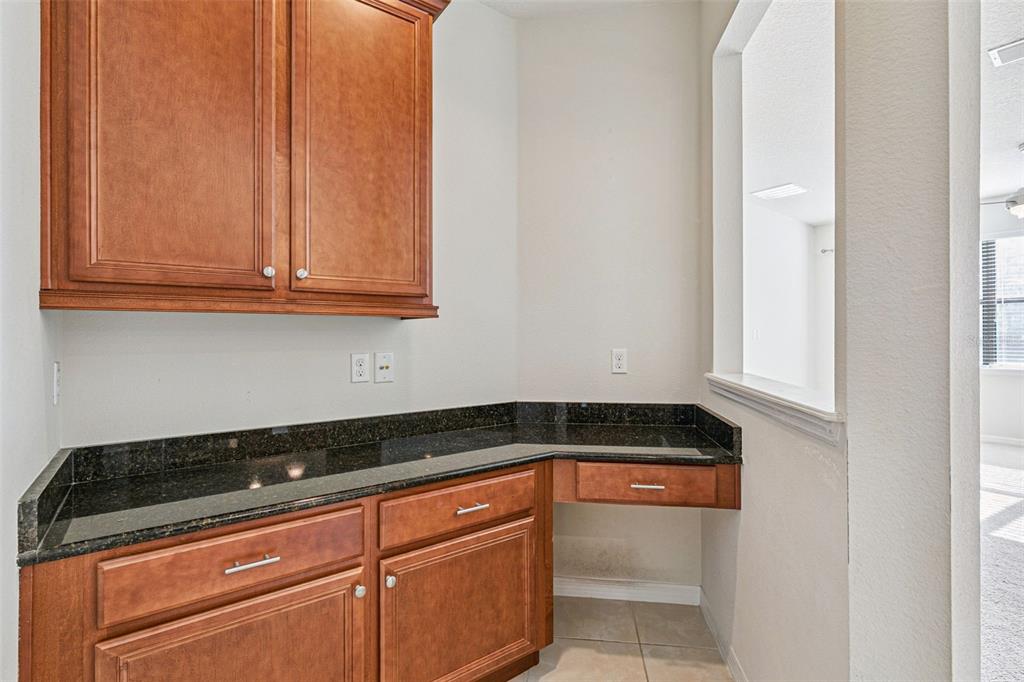 7137 Beek Street Windermere, FL 34786 - Photo 13 of 33 a kitchen with granite countertop white cabinets and sink