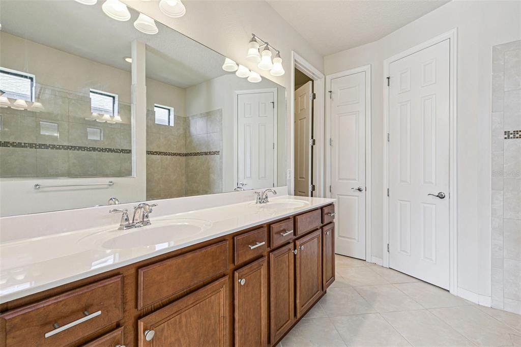 7137 Beek Street Windermere, FL 34786 - Photo 20 of 33 a bathroom with a double vanity sink and a mirror