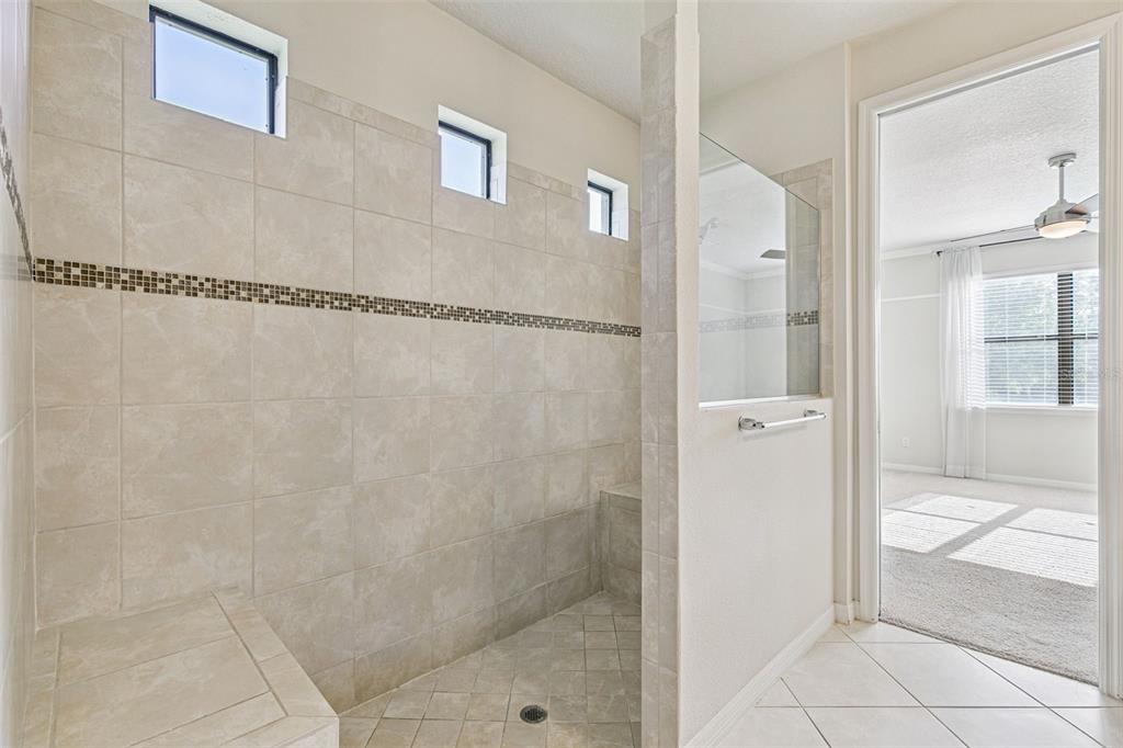 7137 Beek Street Windermere, FL 34786 - Photo 21 of 33 a bathroom with a glass shower door