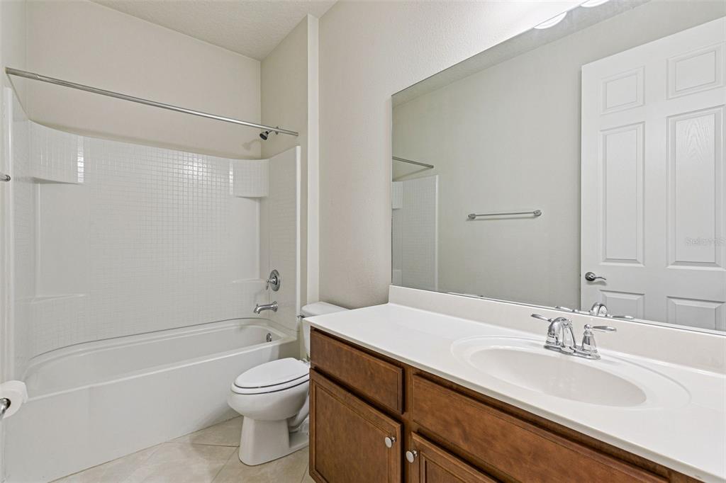 7137 Beek Street Windermere, FL 34786 - Photo 23 of 33 a bathroom with a granite countertop sink a toilet and shower