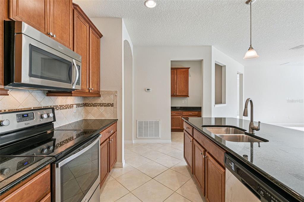 7137 Beek Street Windermere, FL 34786 - Photo 6 of 33 a kitchen with a stove microwave and sink