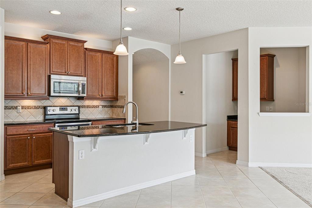 7137 Beek Street Windermere, FL 34786 - Photo 8 of 33 a kitchen with stainless steel appliances granite countertop a refrigerator a sink and a stove