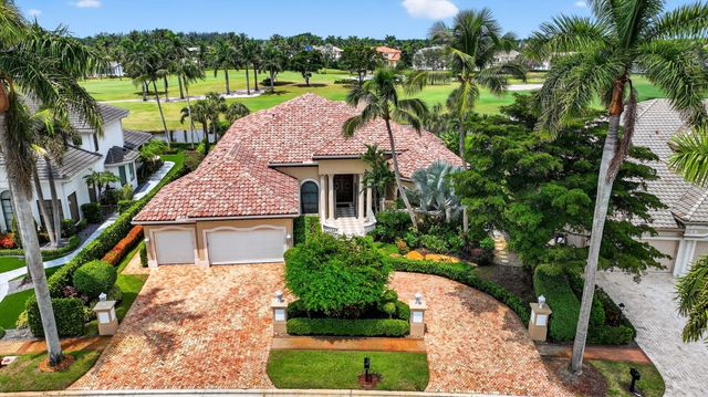 a front view of a house with a yard and lake view