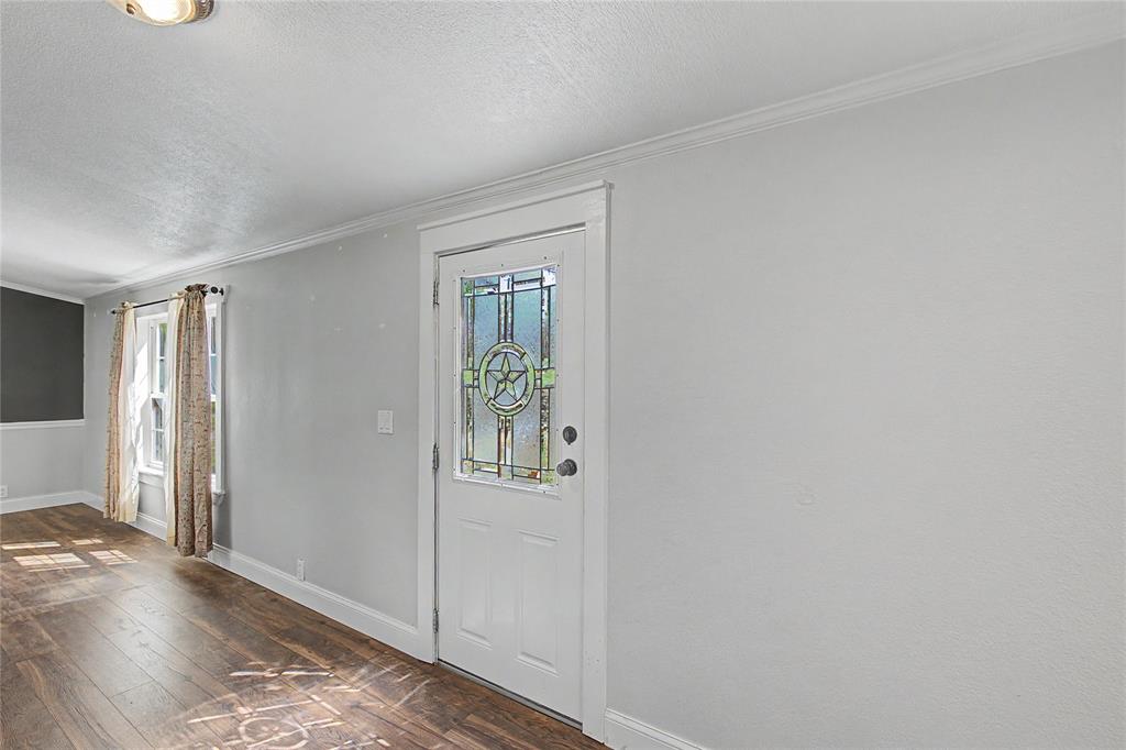 1701 Central Road Weatherford, TX 76088 - Photo 11 of 40 Foyer entrance featuring dark wood-type flooring, ornamental molding, and a textured ceiling