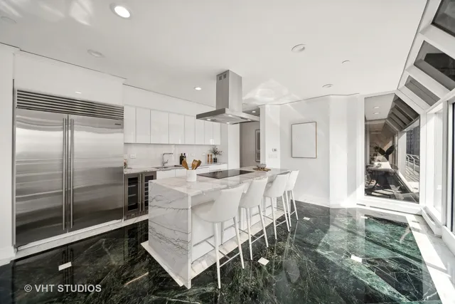 a kitchen with stainless steel appliances granite countertop a refrigerator and a stove top oven