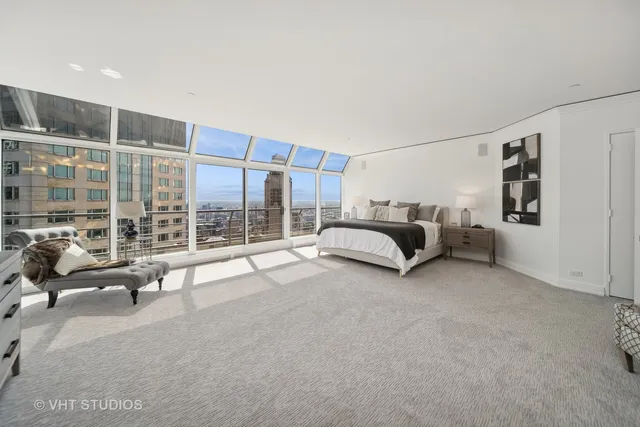 a large bedroom with a bed couch and a large window