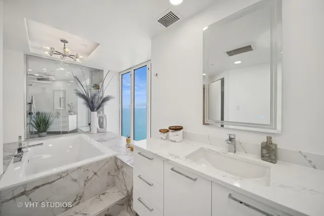 a bathroom with double vanity sinks a vanity a mirror and a shower