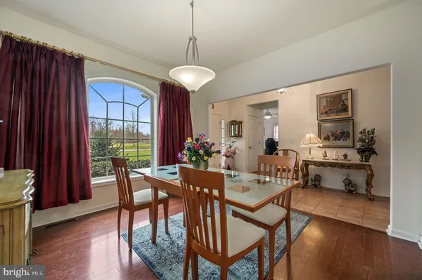a dining room with furniture a chandelier and wooden floor