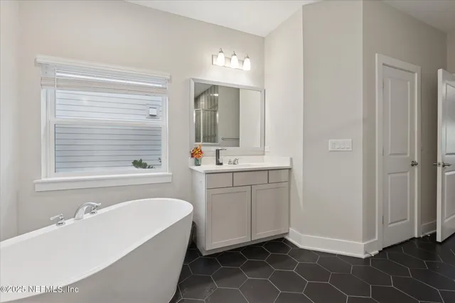 a bathroom with a tub sink and mirror