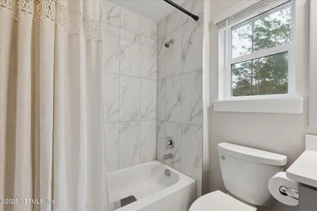 a white toilet sitting next to a bath tub