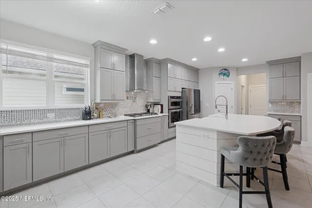 a kitchen with stainless steel appliances granite countertop a sink and a refrigerator