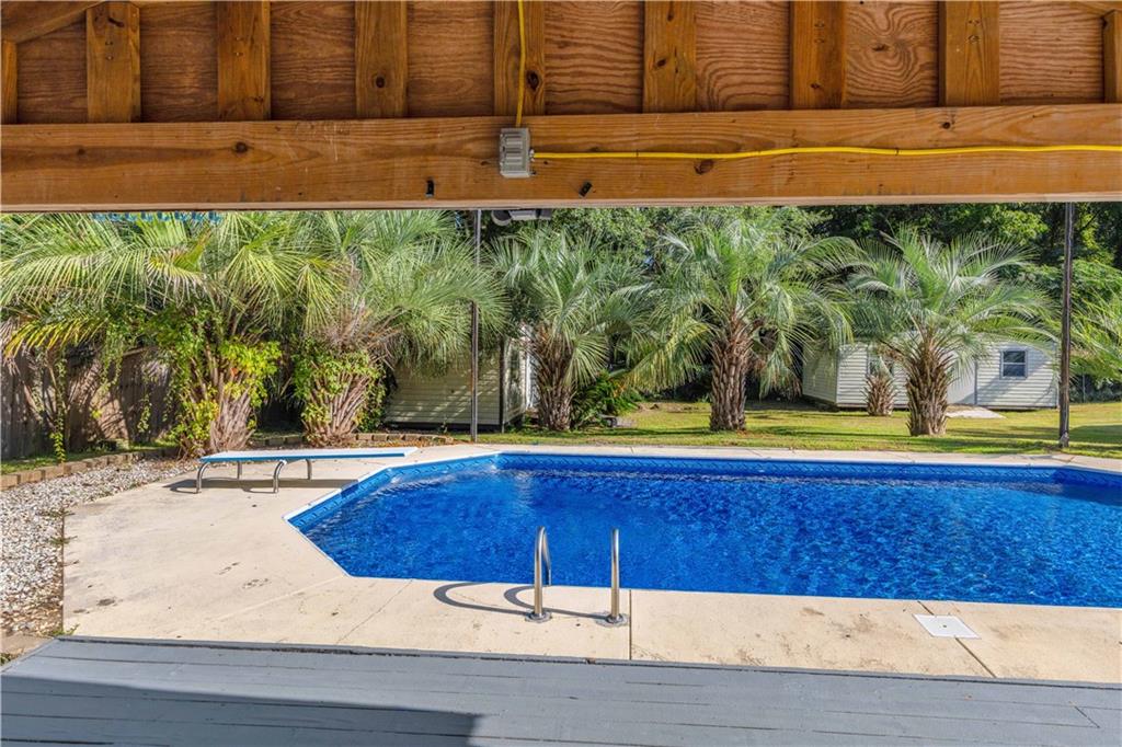 4 Ford Road Phenix City, AL 36869 - Photo 38 of 52 Spacious outdoor entertainment area featuring a built-in swimming pool, concrete patio, and mature palm trees