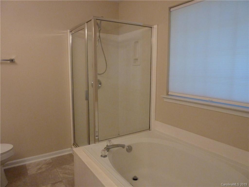 3607 Marbury Road Charlotte, NC 28269 - Photo 12 of 16 a bathroom with a bathtub and a shower