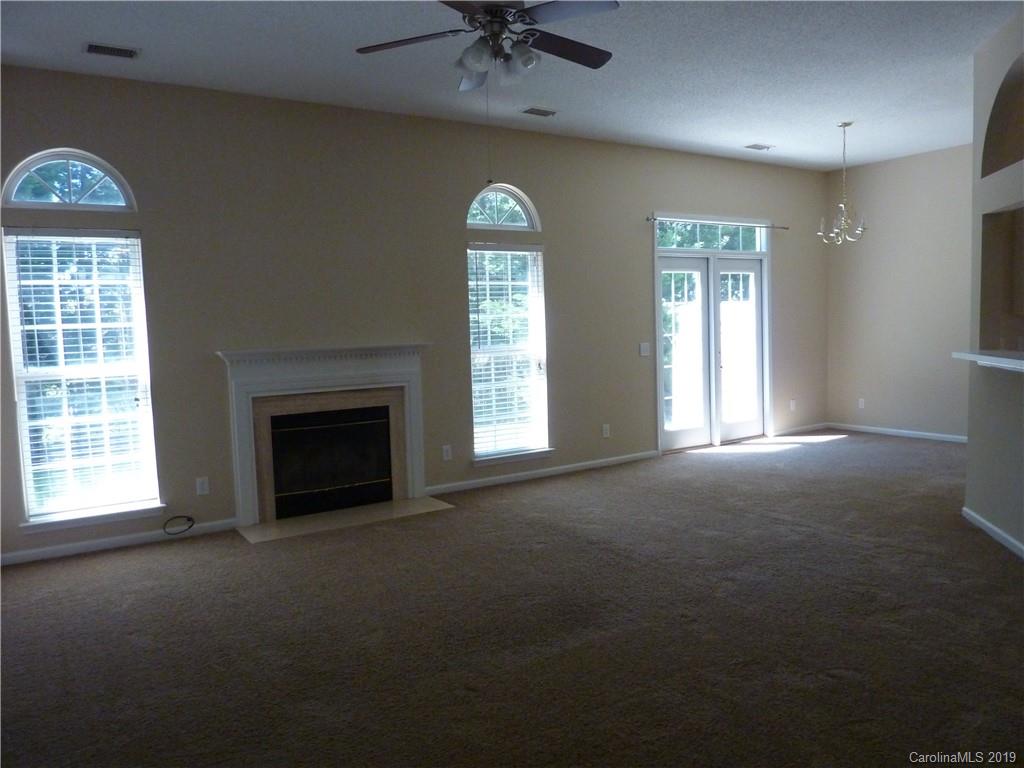 3607 Marbury Road Charlotte, NC 28269 - Photo 4 of 16 an empty room with a fireplace and a window